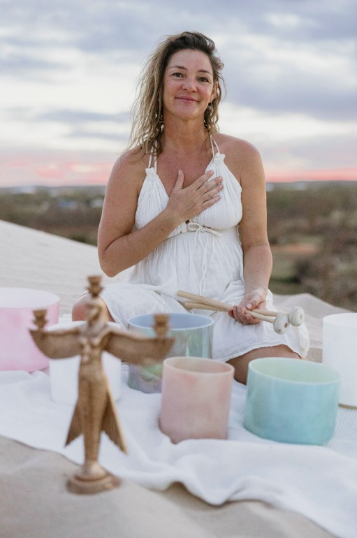 Naomi sitting with at sunset with her crystal bowls